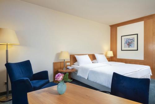 a hotel room with a bed and a table and chairs at Maritim Hotel Frankfurt in Frankfurt/Main