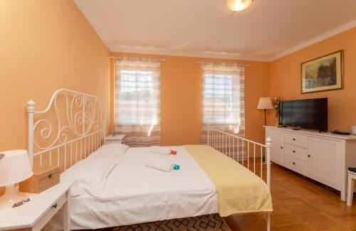 um quarto com uma cama branca e uma televisão de ecrã plano em Seaview apartment Andrea "200 m from the beach" em Mirce