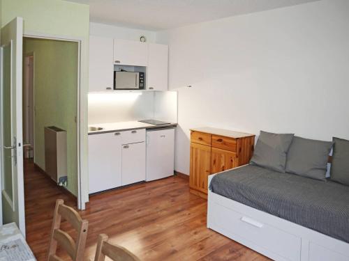 une petite chambre avec un lit et une cuisine dans l'établissement Studio pour 4 au cœur des Orres, proche pistes - FR-1-322-22, aux Orres
