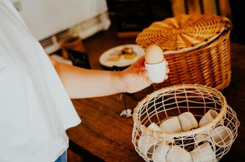 a person holding a cup of eggs in a basket at Alpenrose Bayrischzell Hotel in Bayrischzell