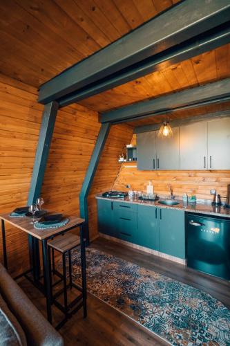 a kitchen with blue cabinets and a table at Twins Bungalow in Sapanca