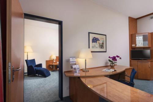 a hotel room with a desk and chairs in a room at Maritim Hotel Frankfurt in Frankfurt/Main