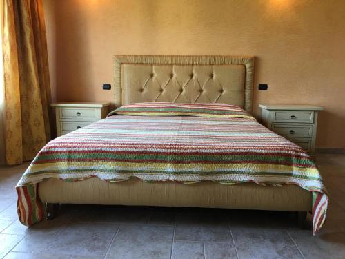 een bed met een kleurrijke deken en twee nachtkastjes bij Borgo dei Normanni in San Vito dei Normanni