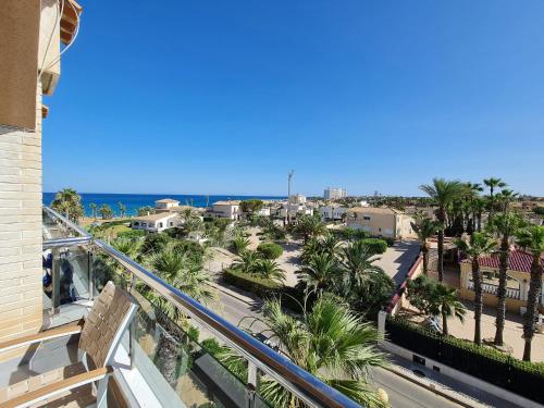 a balcony with a view of a street and palm trees at - - - - - FRONT LINE - - - - - Primera Línea - - - - - Apartments in Playa Flamenca in Playa Flamenca