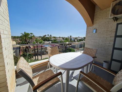 una mesa y sillas en un balcón con vistas en - - - - - FRONT LINE - - - - - Primera Línea - - - - - Apartments in Playa Flamenca en Playa Flamenca