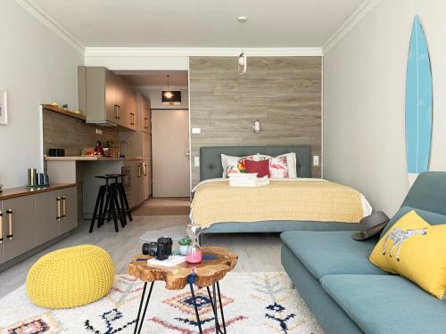 ein Schlafzimmer mit einem Bett und einem blauen Sofa in der Unterkunft A chic lakeside dig - Alexandra Apartment Fonyod in Fonyód