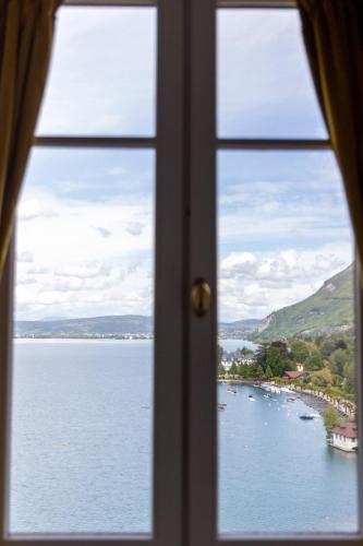 a window with a view of a body of water at Le Palace De Menthon in Menthon-Saint-Bernard