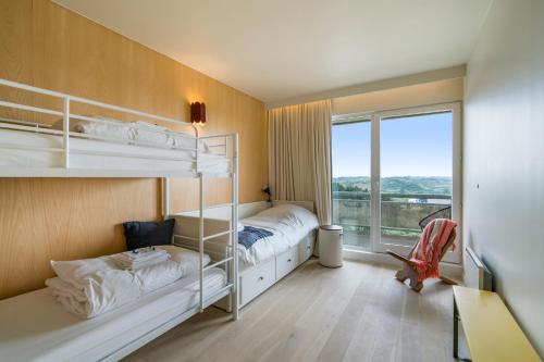une chambre avec deux lits superposés et une fenêtre dans l'établissement Subliem relax app 6p met buitenzwembad & tuin, à La Panne