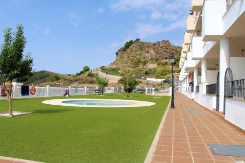 a building with a green lawn in front of a building at Charming apartment in Enix, Almería with shared pool in La Cañada de San Urbano