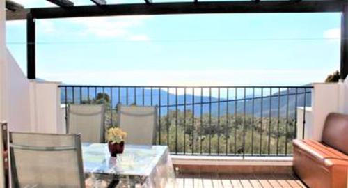 a balcony with a table and a view of the ocean at Charming apartment in Enix, Almería with shared pool in La Cañada de San Urbano