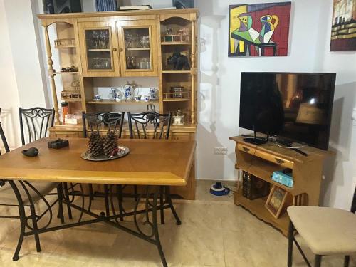 a dining room with a table and a television at Charming apartment in Enix, Almería with shared pool in La Cañada de San Urbano