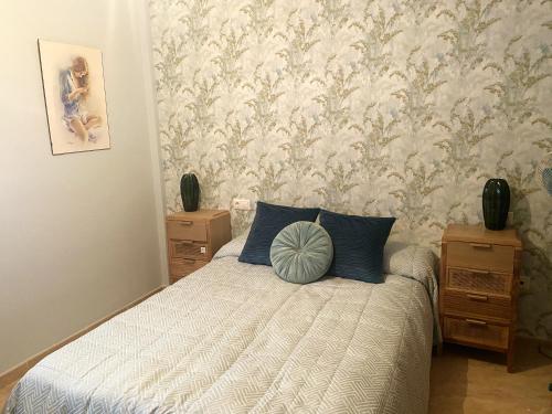 a bedroom with a bed with blue pillows and wallpaper at 2 bedrooms apartement with shared pool enclosed garden and wifi at La Canada in La Cañada de San Urbano