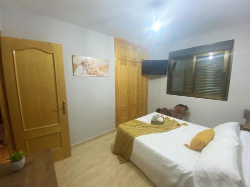 a bedroom with a large white bed and a window at Charming apartment in Enix, Almería with shared pool in La Cañada de San Urbano