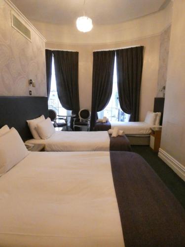 a hotel room with two beds and a desk at Jackson Court Hotel in Dublin