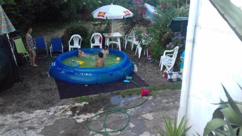 two people are in a swimming pool in a backyard at Calabria Melia di Scilla collina Antico Casale con giardino bio naturale in Castagnarella