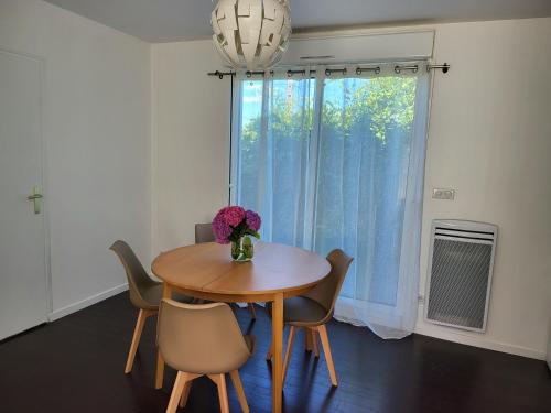 une salle à manger avec une table et des chaises et une fenêtre dans l'établissement maisonnette à 10min de disney, à Jossigny