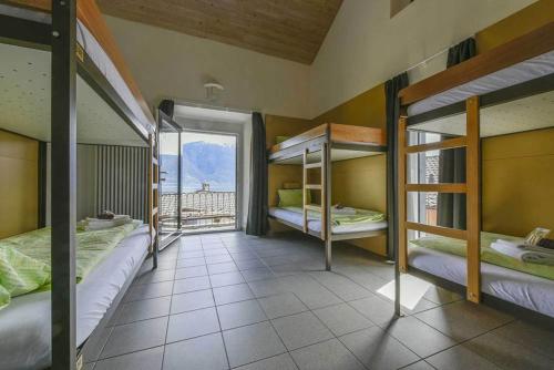 a room with three bunk beds and a balcony at Casa Moscia in Ascona