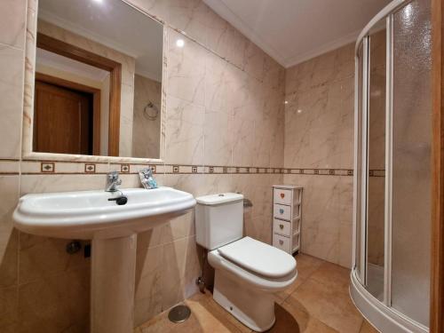 a bathroom with a toilet and a sink and a shower at Apartamento en Playa Rapadoira in Foz