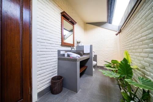 a bathroom with a sink and a mirror at Bruga Villas Restaurant and Spa in Selong Belanak