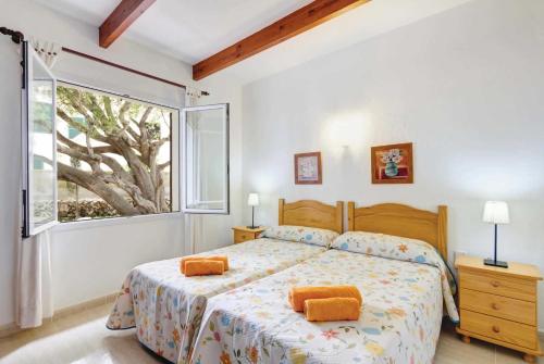 ビニベカにあるBeatrizのベッドルーム1室(オレンジ色の枕と窓付)