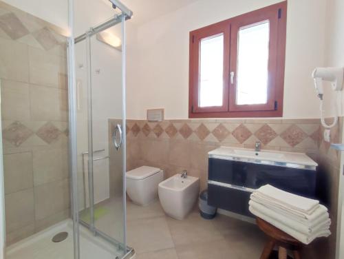 ein Bad mit einer Dusche, einem WC und einem Waschbecken in der Unterkunft Casa Vacanza Luna in SantʼAntìoco