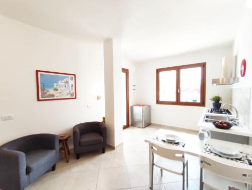 uma cozinha e sala de estar com mesa e cadeiras em Casa Vacanza Luna em SantʼAntìoco