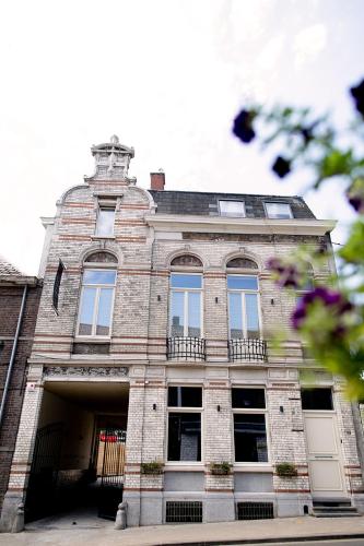 a large brick building with windows on a street at Hôtel de la Poste in Ellezelles