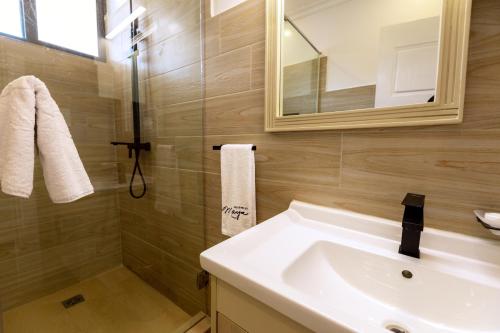 a bathroom with a sink and a shower and a mirror at MAYA Residences Rwanda in Kigali