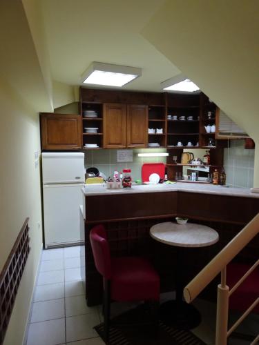 a kitchen with a white refrigerator and a red chair at Pansion Most in Mostar
