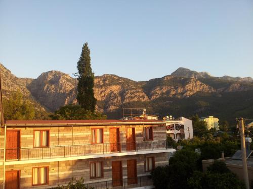 a wooden building with mountains in the background at İPSOS HOTEL BELDİBİ in Kemer