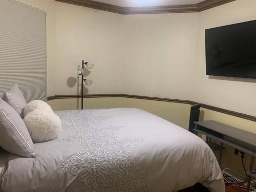 a bedroom with a bed with a television on the wall at Relaxation Zone in West Palm Beach
