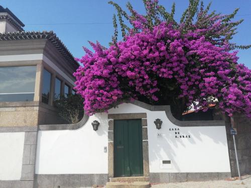 Un mazzo di fiori viola sul lato di un edificio di Casa de São Braz a Landim