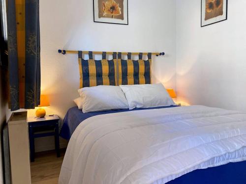 - une chambre avec un lit doté d'une tête de lit rayée dans l'établissement Appartement climatisé, 4 couchages, à 2 pas de la plage au Lavandou - FR-1-251-93, au Lavandou