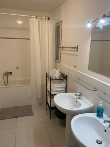 un bagno bianco con lavandino, vasca e specchio di Impeccable 3-Bed Apartment close to the River a Praga