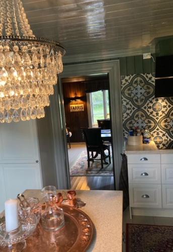 a kitchen with a chandelier and a table with glasses on it at Steinsvoll Gård in Vang I Valdres