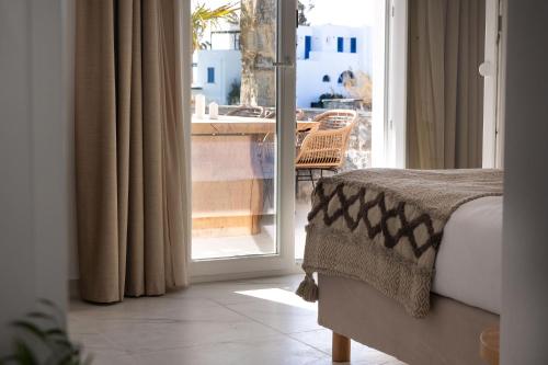 a bedroom with a bed and a door to a balcony at Cosmos Hotel in Plaka