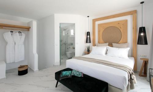 a white bedroom with a large bed and a bathroom at Cosmos Hotel in Plaka