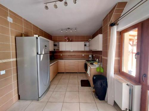 a kitchen with a stainless steel refrigerator and a window at Cabana Sweetlife in Rimetea