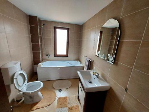 a bathroom with a tub and a toilet and a sink at Cabana Sweetlife in Rimetea