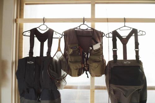 a group of clothes on hangers in front of a window at RONENAI BASE in Biei