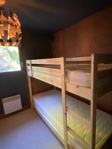 Ce lit superposé se trouve dans un dortoir doté d'une fenêtre. dans l'établissement Spacieux & Chaleureux Apt avec vue panoramique, à Orcières