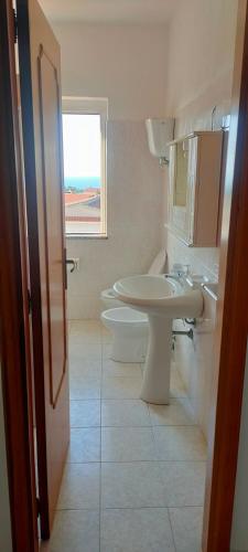 a bathroom with a sink and a toilet at Bova's Apartment in Zambrone