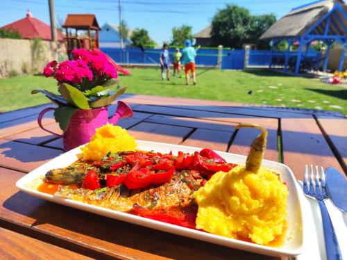 a plate of food on a table with a plate of food at Pensiunea Cuplu Călător in Jurilovca