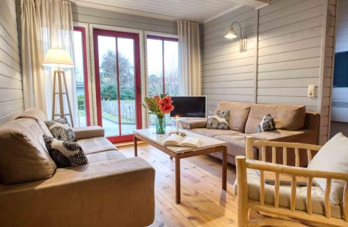a living room with two couches and a table at traumHaff - Sea Hideaway Ostsee Region - privates NORDICSPA, Kamin, Kunst, Hund 300m zum Strand in Rieth