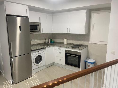 a kitchen with a stainless steel refrigerator and a dishwasher at apartamento isabel in Ardales