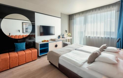 - une chambre d'hôtel avec un lit et un miroir dans l'établissement Hunguest Bük - ex Répce és Répce Gold, à Bük