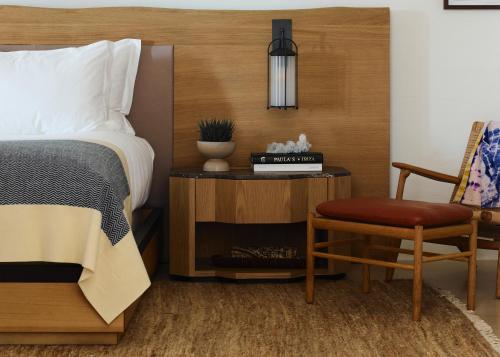 a bedroom with a bed and a chair and a table at Six Senses Ibiza in Portinatx