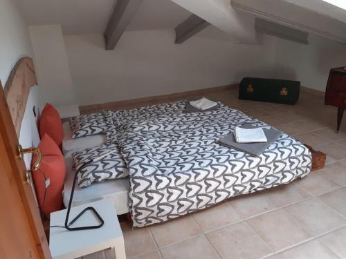 a bedroom with a bed with a black and white comforter at B/B Casa Angela in Firenzuola