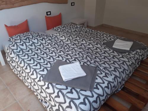 a bedroom with two beds with black and white sheets at B/B Casa Angela in Firenzuola