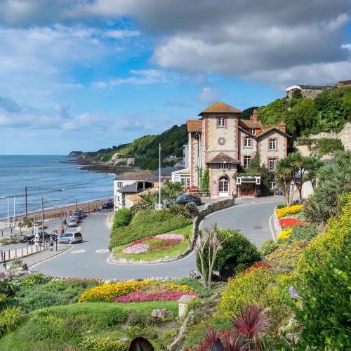 a building on a hill next to the ocean at Bougainvillea in Ventnor